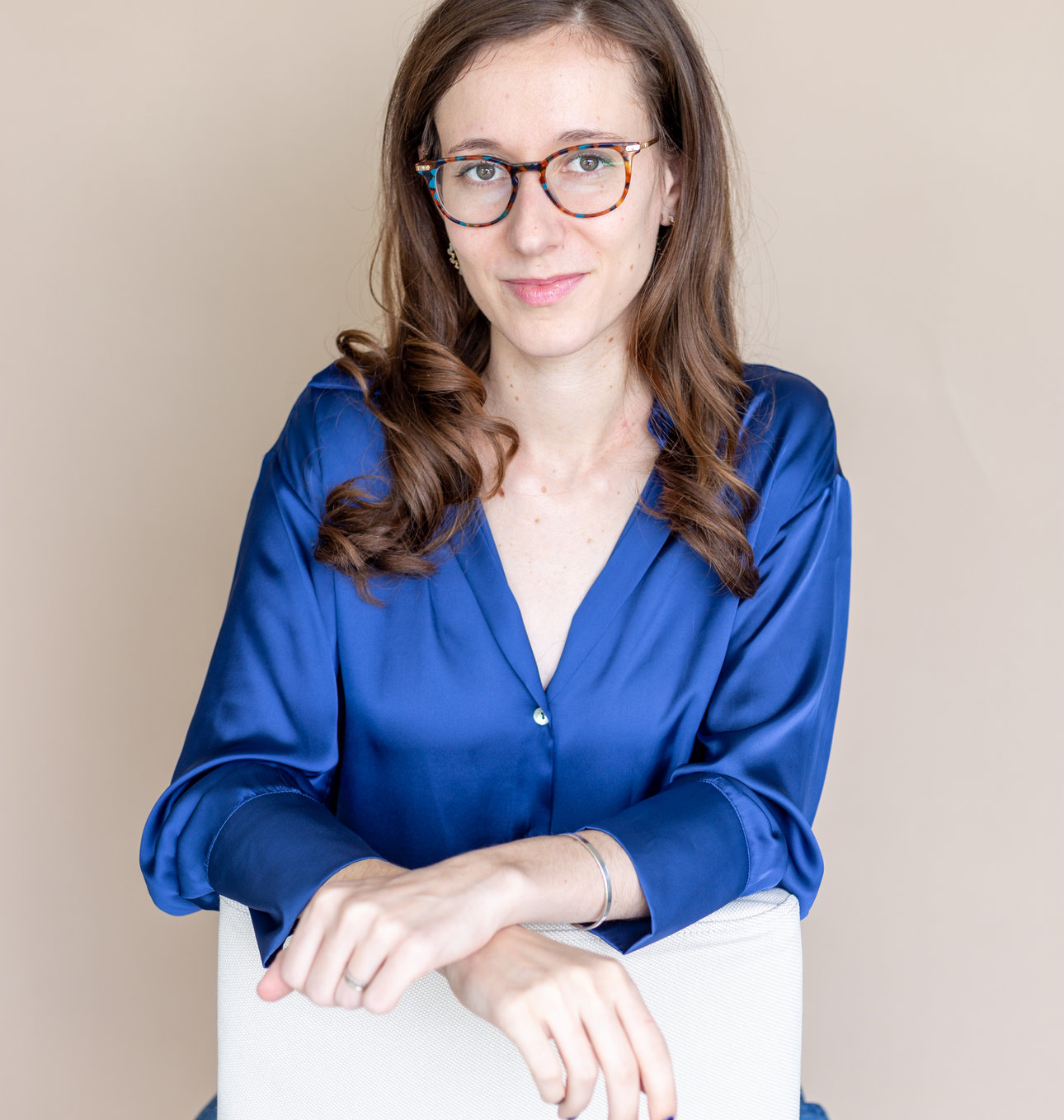 Sara Royf looking at the camera while sitting in a chair